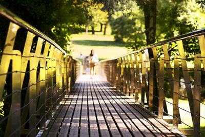 Defocused woman walking on a metal and wooden bridge