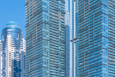 Low angle view of modern buildings against blue sky