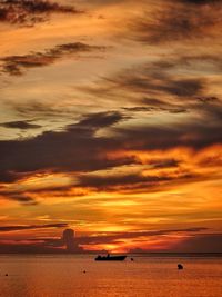 Scenic view of sea against dramatic sky during sunset