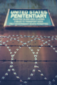 Close-up of text on metal fence