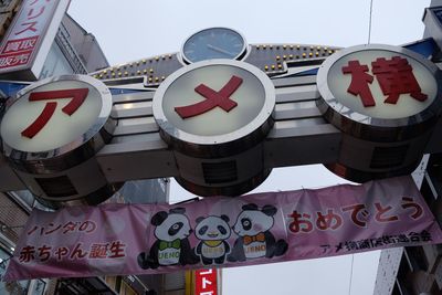 Close-up of directional sign against built structure