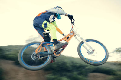 Low angle view of mountain biker performing stunt against clear sky