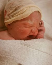 Close-up of baby sleeping in bed