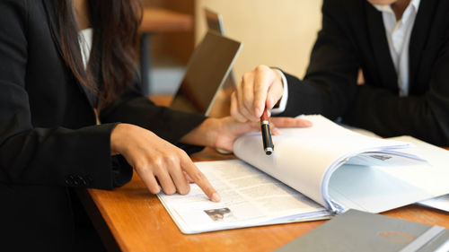 Midsection of woman discussing with colleague