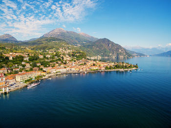 Aerial view of townscape by sea against sky