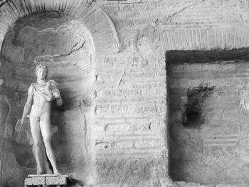 Statue against stone wall