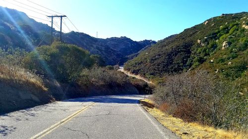 Road by mountain against sky