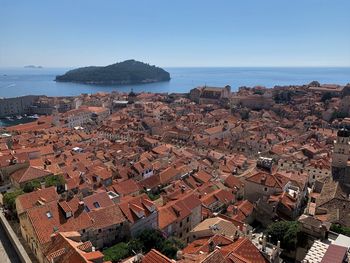 High angle view of townscape by sea against clear sky