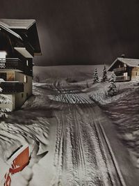 Snow on table by house at night during winter