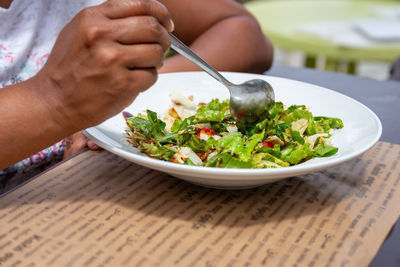 Midsection of man preparing food in bowl on table