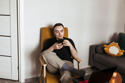 Portrait of young woman sitting on sofa at home