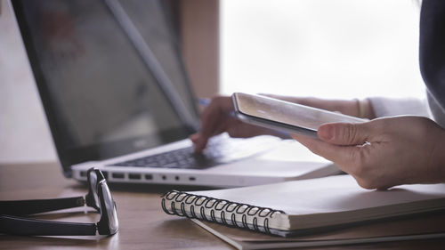 Midsection of businesswoman using mobile phone at office