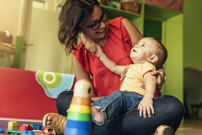 Full length of mother and woman sitting on table