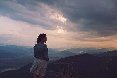 Man standing on mountain against sky during sunset