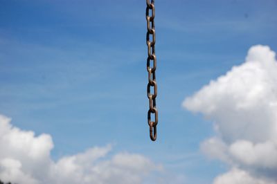 Low angle view of chain against sky