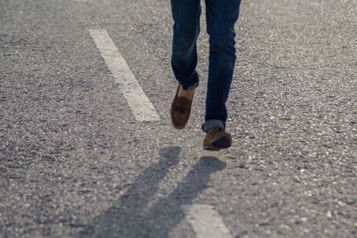 Low section of person standing on road