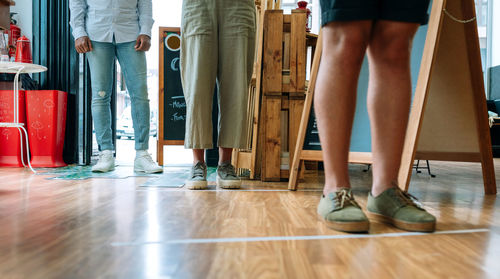 Low section of people standing on tiled floor