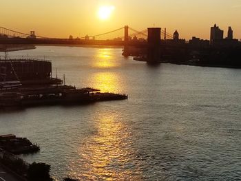 View of suspension bridge in city at sunset