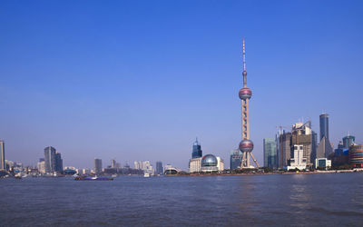 Modern buildings in city against blue sky