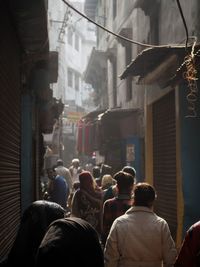 Rear view of people on street amidst buildings