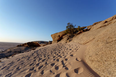 Scenic view of beach against clear blue sky