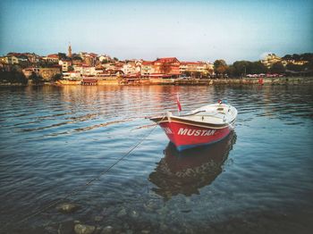 Boat in river with buildings in background