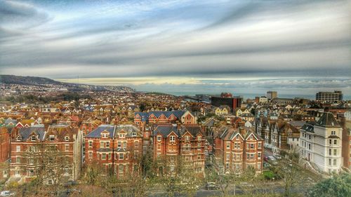 View of cityscape against cloudy sky