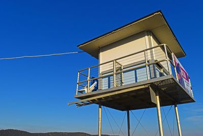 Low angle view of windmill against clear blue sky