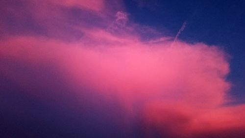Low angle view of pink rainbow against sky during sunset