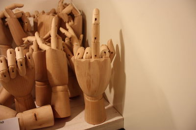 Close-up of artificial hands on table against wall