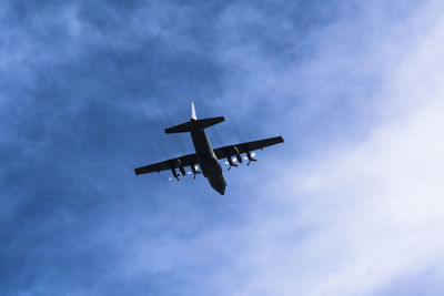 Low angle view of airplane against blue sky