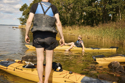 Men at lake relaxing near kayaks