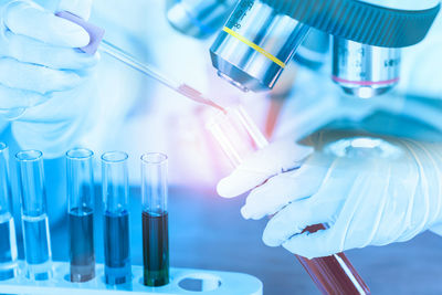 Midsection of scientist examining chemical in laboratory