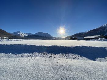 Scenic view of snowcapped mountains against blue sky