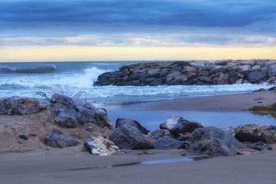 Rocks on beach against sky