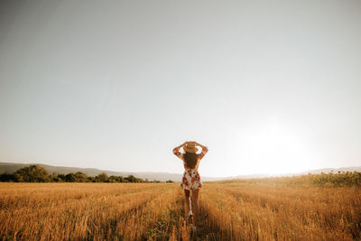 Full length of man standing on field against clear sky