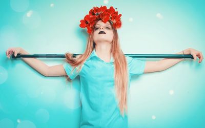 Portrait of beautiful young woman standing against multi colored background