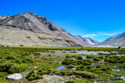 Scenic view of mountains against blue sky