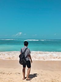 Full length rear view of woman walking on beach