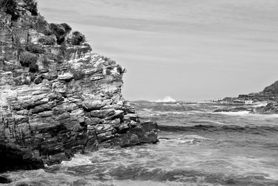 Rock formation on sea against sky