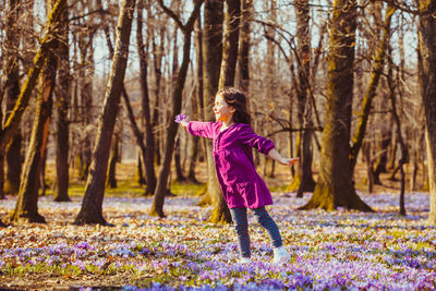 Full length of girl standing against trees