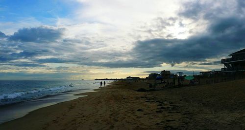 Scenic view of beach against cloudy sky