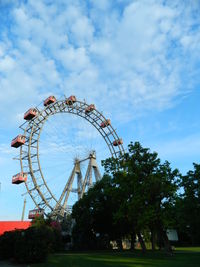 Low angle view of trees against cloudy sky