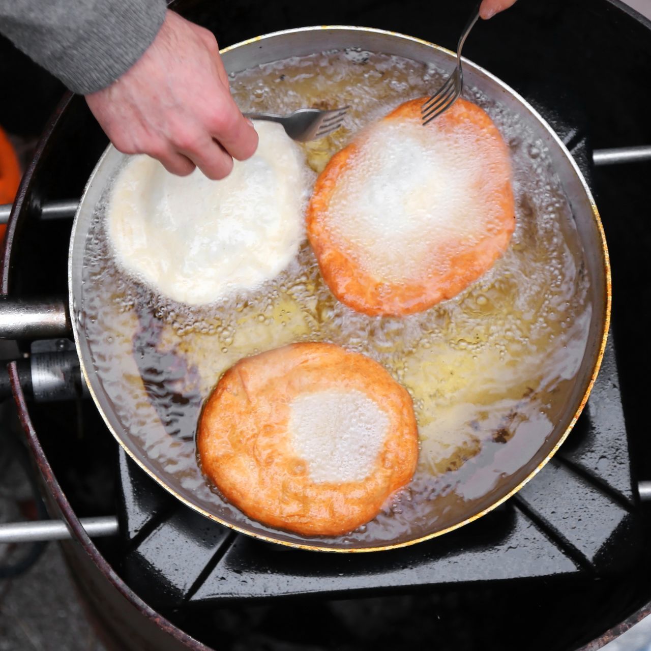 CLOSE-UP OF PERSON PREPARING FOOD IN KITCHEN