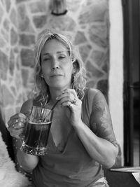 Portrait of mature woman holding alcoholic drink at home