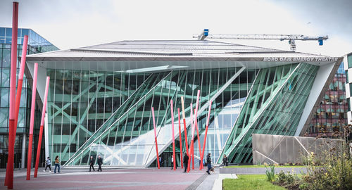 People in modern building against sky