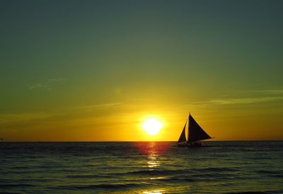 Sailboat in sea during sunset