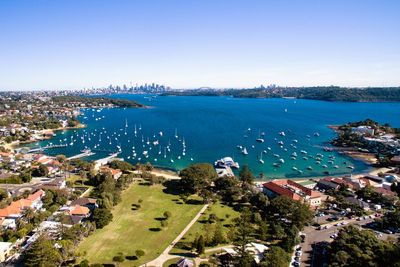 High angle view of sea and town against blue sky