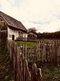 Wooden fence on field against sky