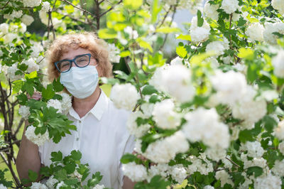 Portrait of man with pink flowers in garden